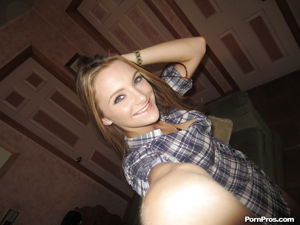 Молодая американка в рубашке позирует дома на камеру Айфона 1 фотка